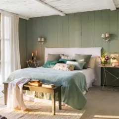 Habitación con paredes verde menta, cama con ropa de cama azul claro y cojines verdes. Inspiración de colores para habitaciones.