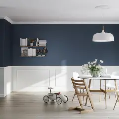 Elegante comedor con paredes azul marino y blanco, destacando las molduras en paredes y un juego de mesa con sillas.