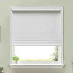 Ventana con estor enrollable blanco, ideal para aprender cómo hacer un estor. Al lado, un cuadro y toallas.