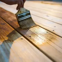 Aplicando barniz sobre barniz sin lijar, una mano de protección para la madera.