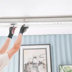 Persona con guantes cambia un tubo fluorescente por uno LED con cebador, mejorando la iluminación.