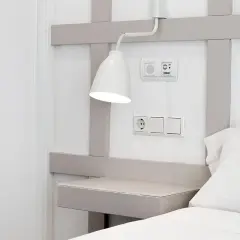 Interruptores y enchufe cerca del cabecero de la cama, con una lámpara orientable. La distancia entre interruptores cabecero cama es ideal para el control de luces.