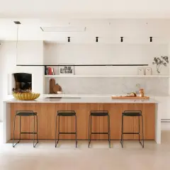 Cocina moderna con isla de madera y taburetes. Un proyecto de restaurar muebles de cocina podría dar vida a este espacio.