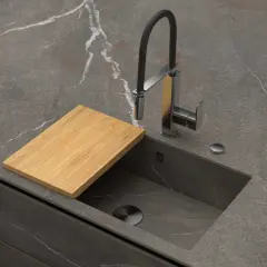 Encimera de cocina moderna con fregadero integrado, grifo flexible y tabla de cortar de bambú. Explora los tipos de fregaderos.