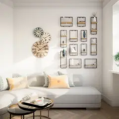 Acogedora sala de estar pequeña con sofá gris, cojines color crema y menta, y una pared decorada con relojes y estanterías flotantes.
