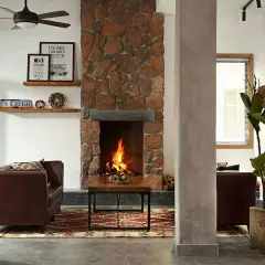 Ideas para como decorar una chimenea rustica: piedra, madera y un fuego acogedor.