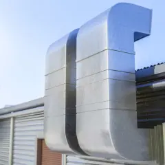 Grandes conductos metálicos para tapar shunt ventilación en una edificación industrial.