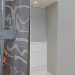 Instalación de estructura metálica para colocar pladur. A la derecha, pared terminada en gris claro.