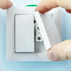 Manos instalan tapa en un interruptor doble Simon.