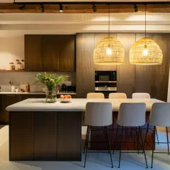 Cocina alargada con isla central y taburetes. Solución ideal para cómo distribuir una cocina alargada, maximizando el espacio y creando un área funcional.
