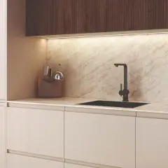 Encimera de cocina de mármol veteado con fregadero negro y grifo. Muestra varios tipos de encimeras de cocina.