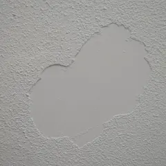 Detalle de paredes con gotele, mostrando una zona reparada con textura lisa sobre la rugosidad original.