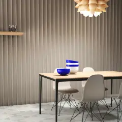 Ideas para tapar paredes feas: panelado vertical texturizado, estantería de madera y mesa de comedor con sillas modernas.