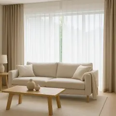 Sofá beige y cortinas de lino, un ejemplo de las últimas tendencias cortinas salón. Tonos neutros y luz natural.