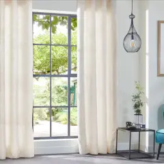 Elegantes cortinas de tela crema con sutil estampado, ideales para distintos tipos de cortinas para ventanas, complementan un sillón turquesa y un cuadro abstracto.
