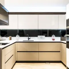 Cocina moderna con gabinetes blancos y beige, encimera blanca, campana extractora de acero inoxidable. Ideas para como diseñar una cocina funcional y elegante.
