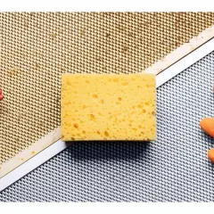 Esponja, guantes naranjas y spray listos para limpiar extractor cocina.