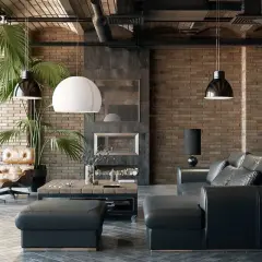 Sofá de cuero negro y sillón de cuero marrón junto a paredes estilo industrial de ladrillo visto. Chimenea y plantas verdes completan el ambiente.