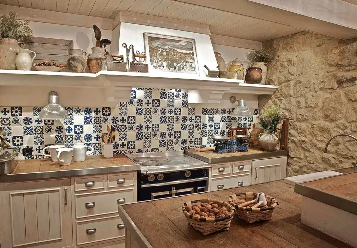 Encantadora cocina rústica con azulejos azules y blancos, encimeras de madera y piedra. Ideal para preparar deliciosas comidas.