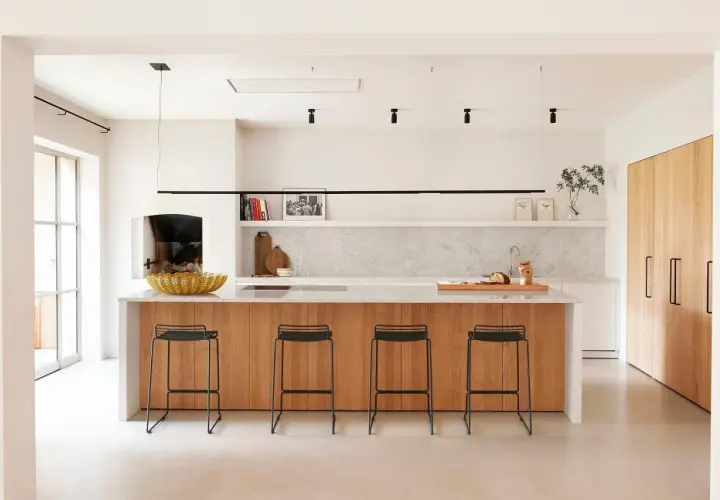 Cocina moderna con isla de madera y taburetes. Un proyecto de restaurar muebles de cocina podría dar vida a este espacio.