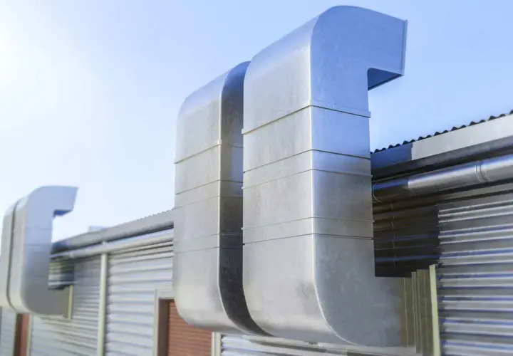 Grandes conductos metálicos para tapar shunt ventilación en una edificación industrial.