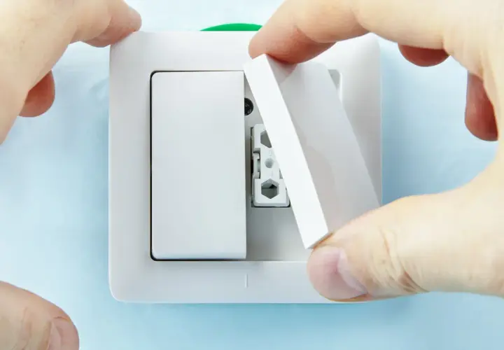 Manos instalan tapa en un interruptor doble Simon.