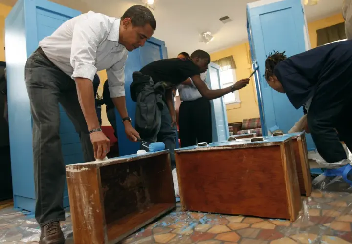Barack Obama y jóvenes pintan muebles de melamina de azul.