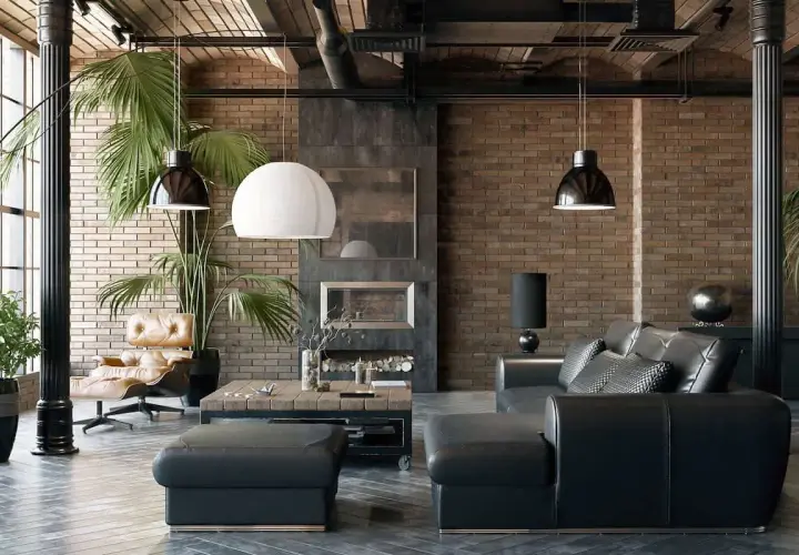 Sofá de cuero negro y sillón de cuero marrón junto a paredes estilo industrial de ladrillo visto. Chimenea y plantas verdes completan el ambiente.