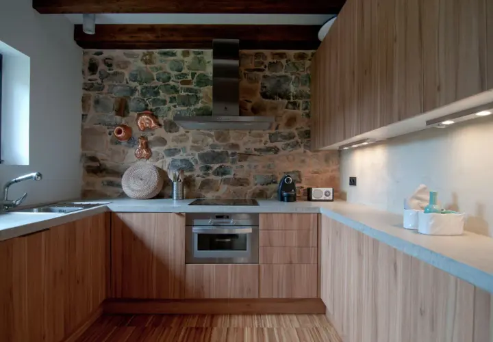 Elegantes diseños de cocinas rústicas con pared de piedra, muebles de madera y encimeras de hormigón.