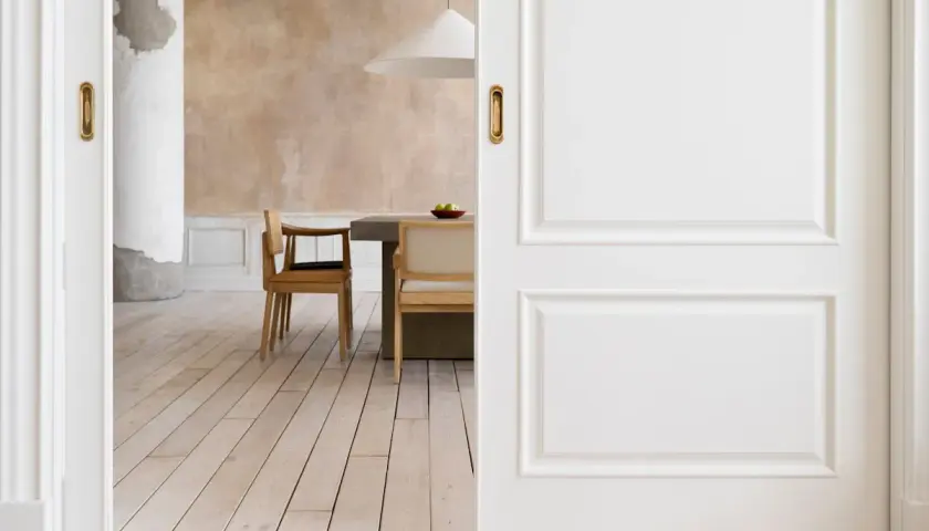 Puertas blancas y suelo de madera clara crean un ambiente acogedor. El diseño busca combinar suelo y puertas para una estética armoniosa.