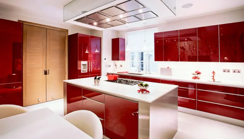 Cocinas rojas modernas con isla central, electrodomésticos integrados y puertas de madera.