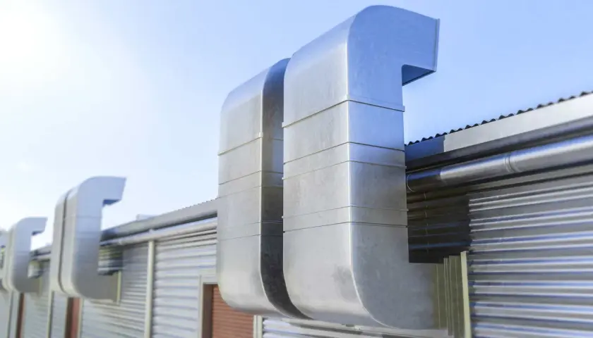 Grandes conductos metálicos para tapar shunt ventilación en una edificación industrial.