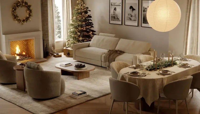 Acogedor **salón de Navidad** con chimenea encendida, árbol decorado, sofá, mesa puesta y una corona luminosa.