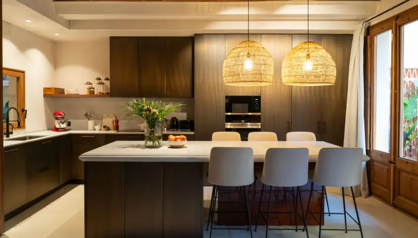 Cocina alargada con isla central y taburetes. Solución ideal para cómo distribuir una cocina alargada, maximizando el espacio y creando un área funcional.