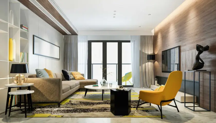 Un salón moderno con sofá marrón, alfombra llamativa y acentos amarillos. La iluminación indirecta en el techo y la pared de madera crea un ambiente cálido, ideal para saber como iluminar un salon.