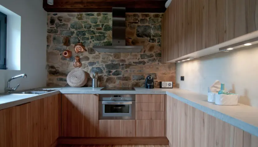 Elegantes diseños de cocinas rústicas con pared de piedra, muebles de madera y encimeras de hormigón.