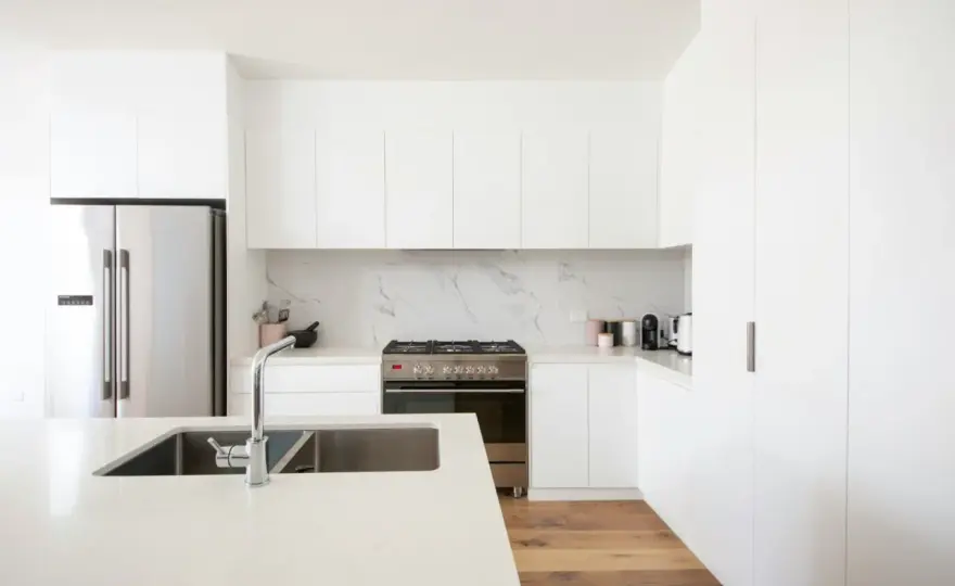 Cocinas blancas modernas con piedra natural y calidez