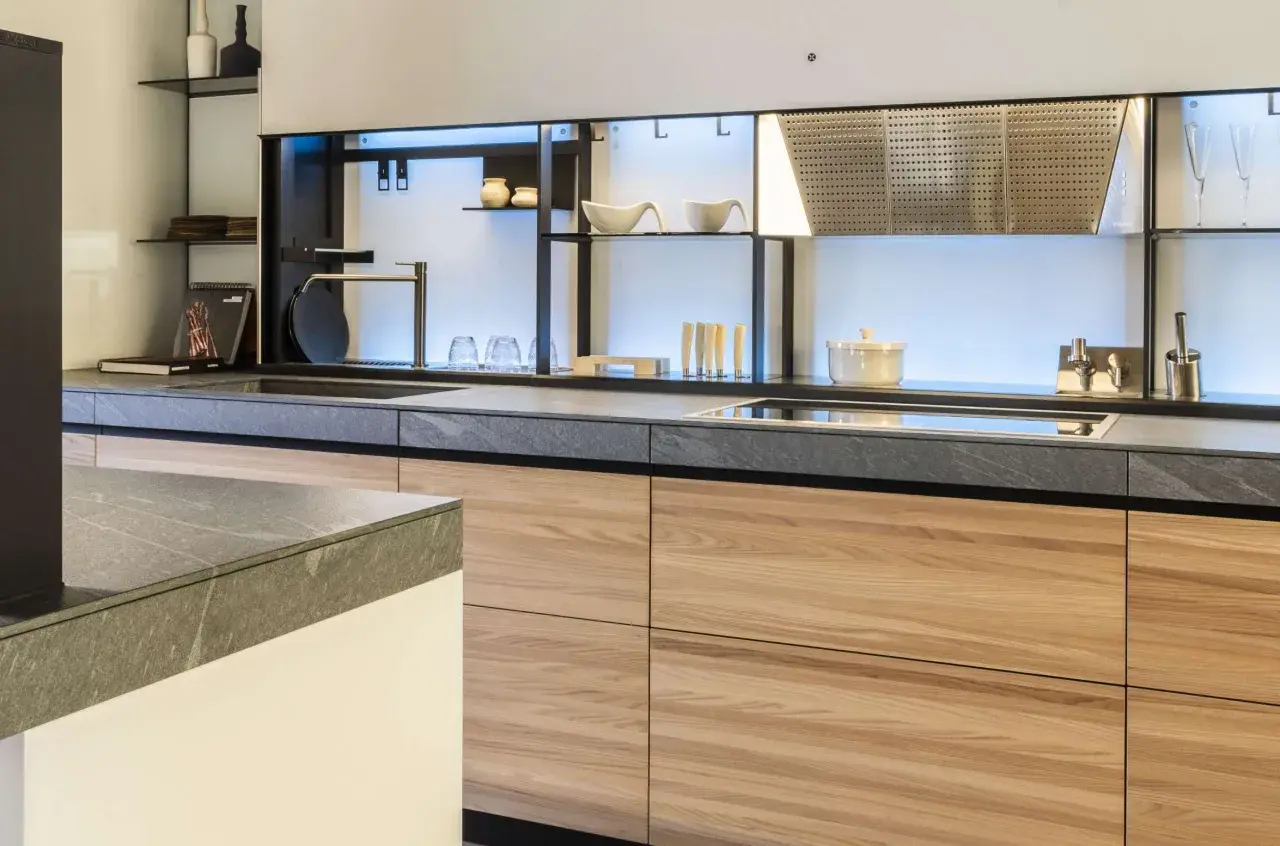 Encimeras resistentes al calor de piedra gris y gabinetes de madera clara en una cocina moderna.