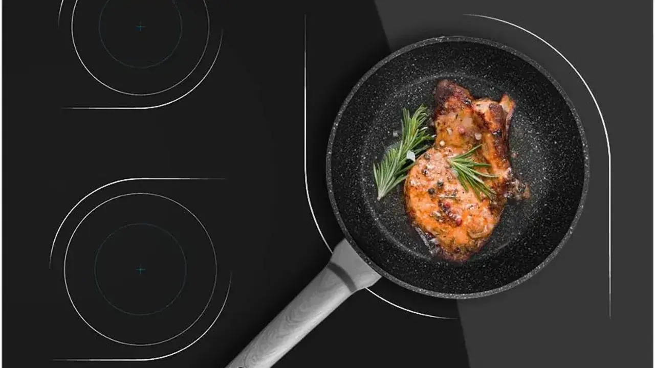 Un filete jugoso se cocina en una sartén sobre una placa de inducción. Aprende como limpiar la placa de inducción para mantenerla impecable.
