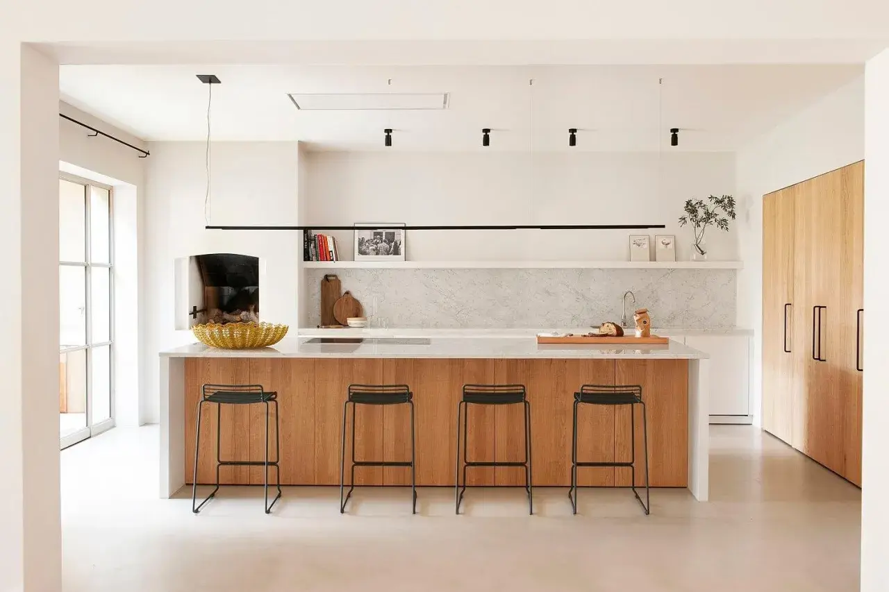 Cocina moderna con isla de madera y taburetes. Un proyecto de restaurar muebles de cocina podría dar vida a este espacio.