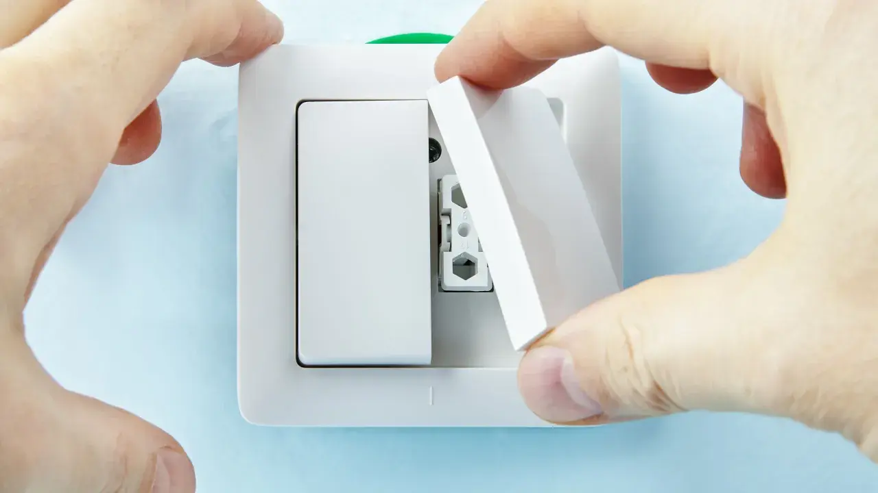 Manos instalan tapa en un interruptor doble Simon.