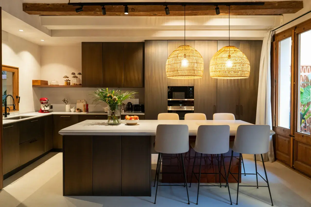 Cocina alargada con isla central y taburetes. Solución ideal para cómo distribuir una cocina alargada, maximizando el espacio y creando un área funcional.