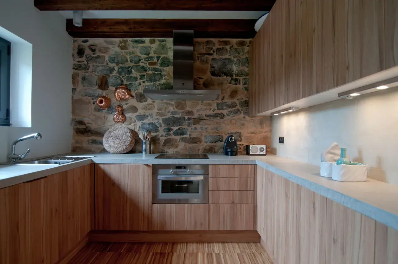 Elegantes diseños de cocinas rústicas con pared de piedra, muebles de madera y encimeras de hormigón.