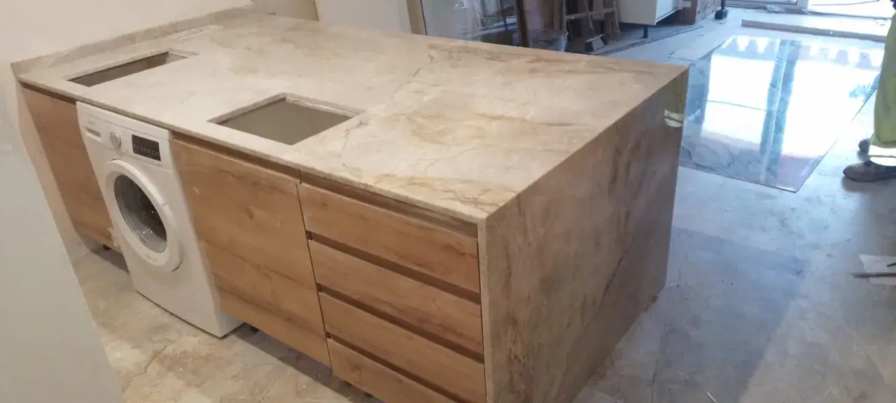 Instalar lavadora en encimera de m&aacute;rmol con muebles de madera.