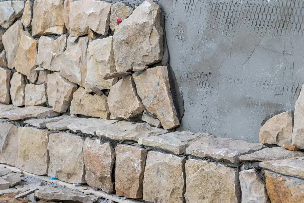 Construcci&oacute;n de muros de piedra natural, mostrando diferentes tipos de paredes y su colocaci&oacute;n.