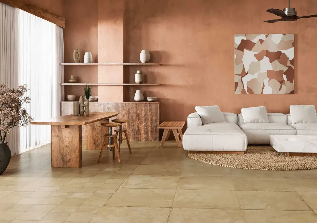 Un sal&oacute;n estilo mediterr&aacute;neo con paredes terracota, muebles de madera r&uacute;stica, sof&aacute; blanco y arte abstracto.