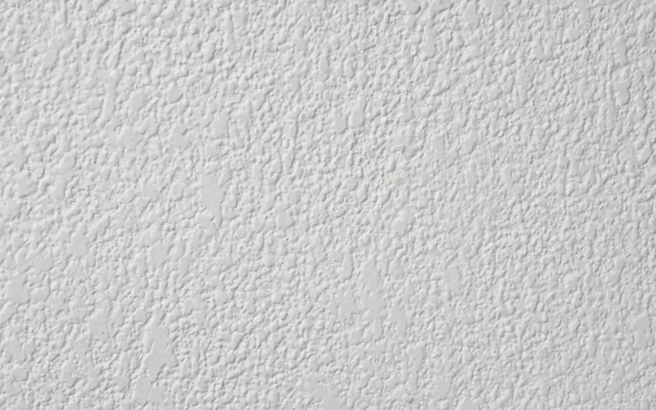 Textura de paredes con gotele blanco, creando un patr&oacute;n irregular y rugoso que da profundidad.