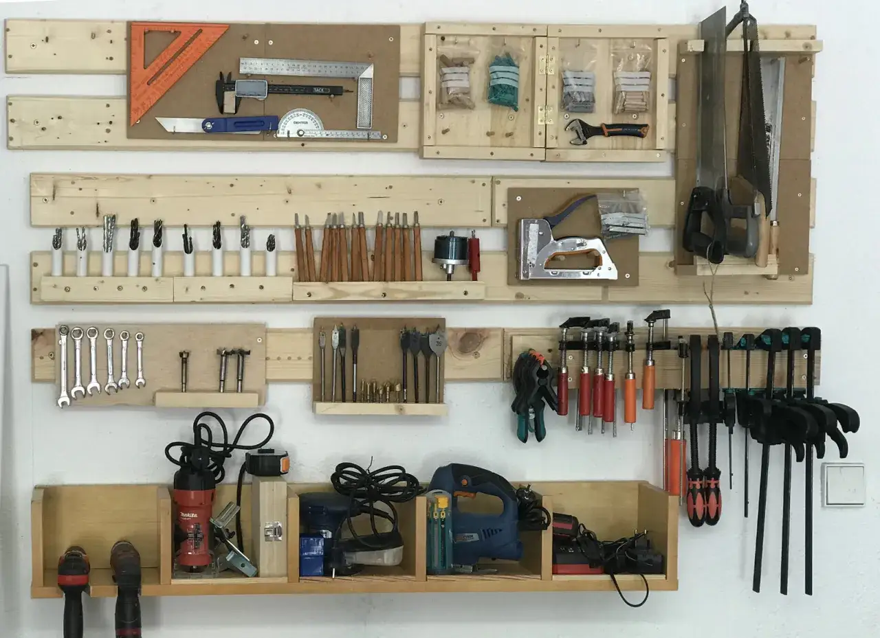 Organizado taller de bricolaje dom&eacute;stico con herramientas de medici&oacute;n, brocas, cinceles, sierras, grapadora, llaves, sargentos y herramientas el&eacute;ctricas.