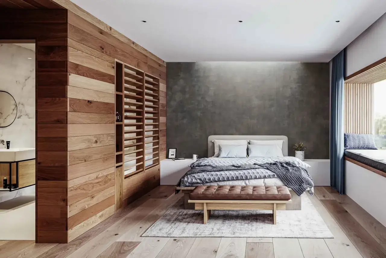 Una pared de madera y estanterías abiertas ayudan a separar ambientes sin obras, creando un espacio acogedor con cama y baño integrados.
