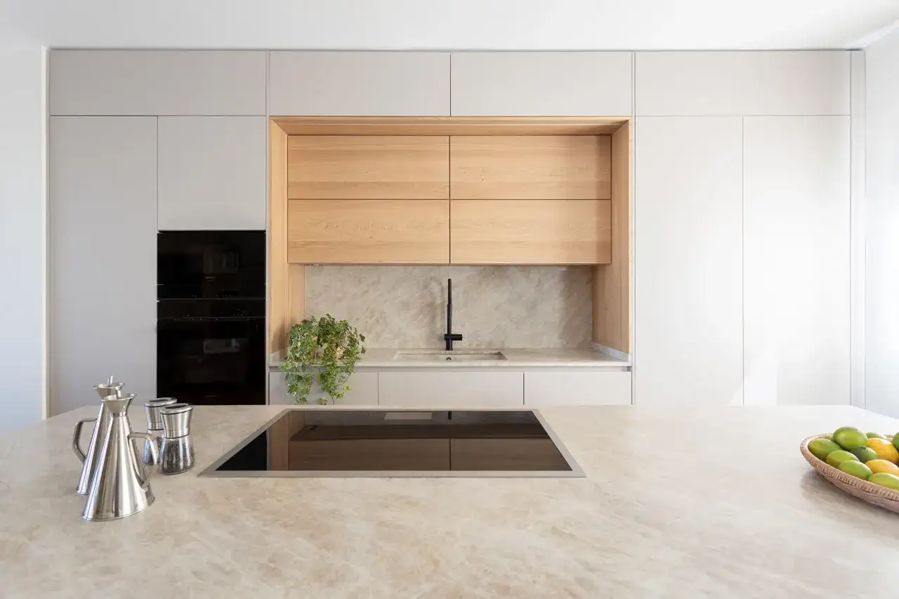 Elegante cocina con encimera de m&aacute;rmol y gabinetes de madera clara. La combinaci&oacute;n de colores para cocina es moderna y acogedora.